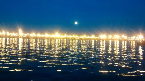 Scenic view of lake against sky at night