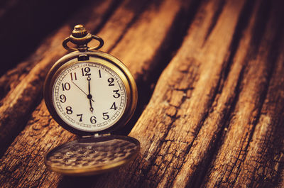 Close-up of pocket clock on wooden table