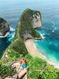 High angle view of woman on rock by sea