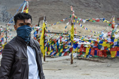 Portrait of man covering face with handkerchief while standing outdoors