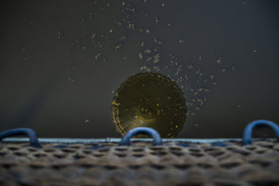 Close-up of water drops on metal against sky