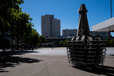 Road by buildings against sky in city