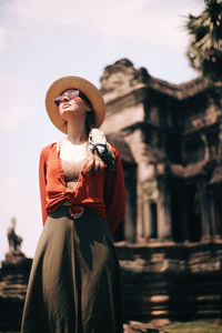 Portrait of woman wearing hat standing outdoors