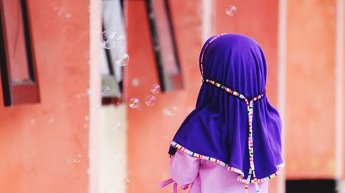 Rear view of girl standing by bubbles