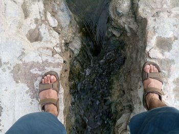 Low section of person standing on rock