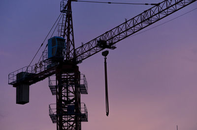 Low angle view of crane against sky during sunset