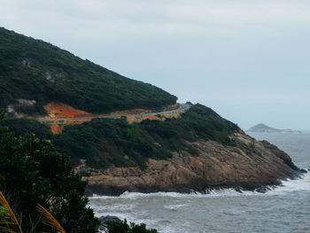 Mountain by sea against sky