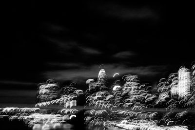 Low angle view of illuminated cemetery against sky at night