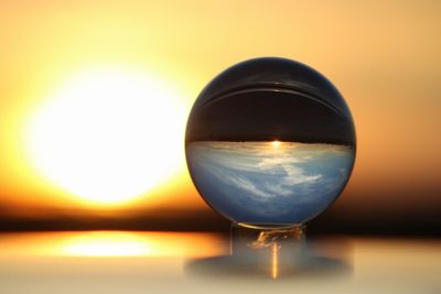 Close-up of wineglass against sunset