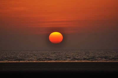 Scenic view of sea against orange sky