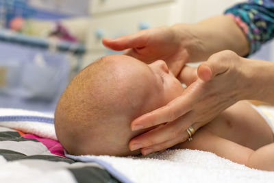 Close-up selective focus shot of baby with seborrheic dermatitis being cared for by her mother