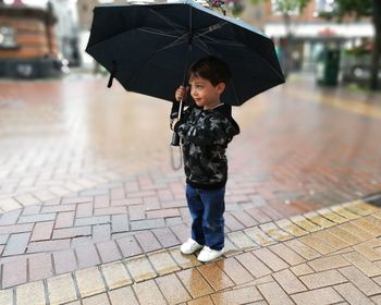 Full length of boy walking on wet street