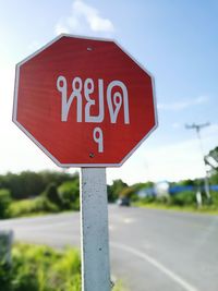 Close-up of road sign against sky