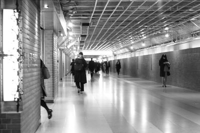 People walking in illuminated underground walkway