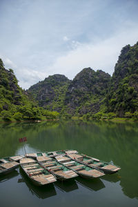 Scenic view of lake by mountains against sky