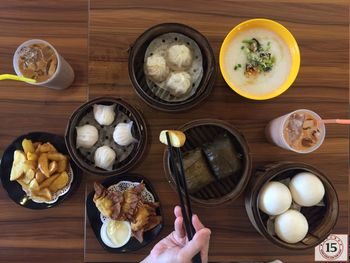 Cropped image of person having various food on restaurant table