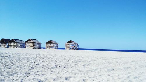 Panoramic view of beach against clear blue sky