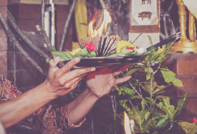 Close-up of human hands holding religious offerings