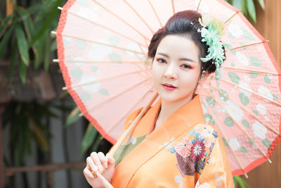Portrait of beautiful woman holding umbrella