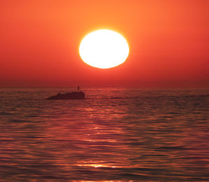 Scenic view of sea against orange sky