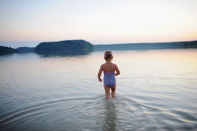 Rear view of girl standing in lake