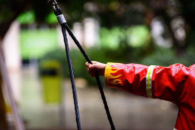 Cropped hand of boy holding rope