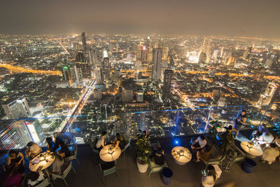 High angle view of illuminated cityscape against sky at night