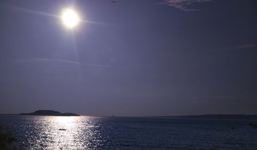 Scenic view of sea against bright sun