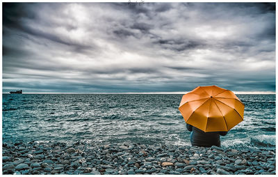 Umbrella on beach against sky