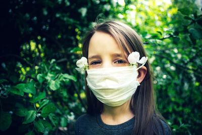 Portrait of girl wearing mask and flowers