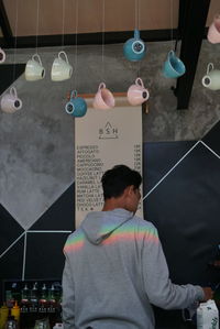 Rear view of man holding balloons