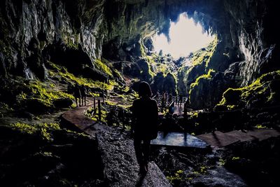 Rear view of man in cave