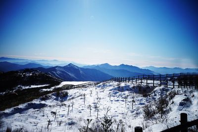 Scenic view of mountains against clear blue sky during winter