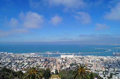 High angle view of city by sea against sky