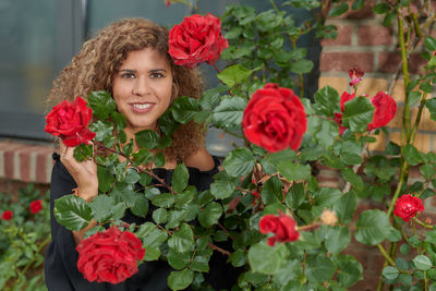 Portrait of smiling woman with red roses