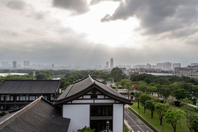 Buildings in city against cloudy sky