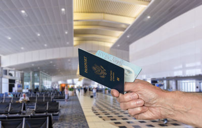 Cropped image of hand holding passport in airport