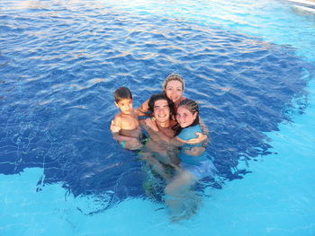 High angle view portrait of happy siblings in sea