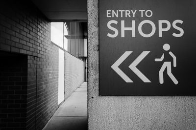 Close-up of directional sign on wall