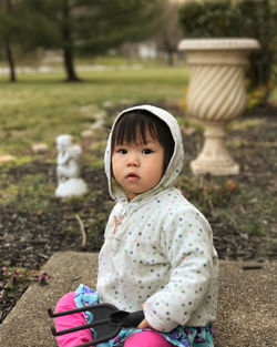 Portrait of cute girl sitting outdoors