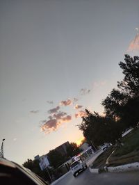 Cars on road against sky during sunset