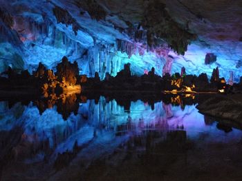 Reflection of people on water in cave