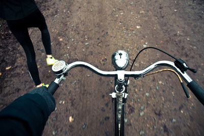 Cropped hand of person riding bicycle on road