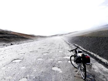 Bicycle on road against clear sky