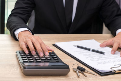 Low section of man with hands on table