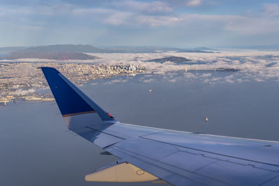 Cropped airplane wing over sea