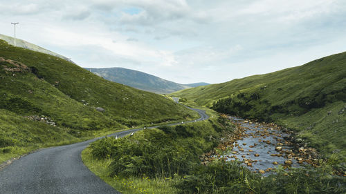 Scenic view of road amidst mountains against sky