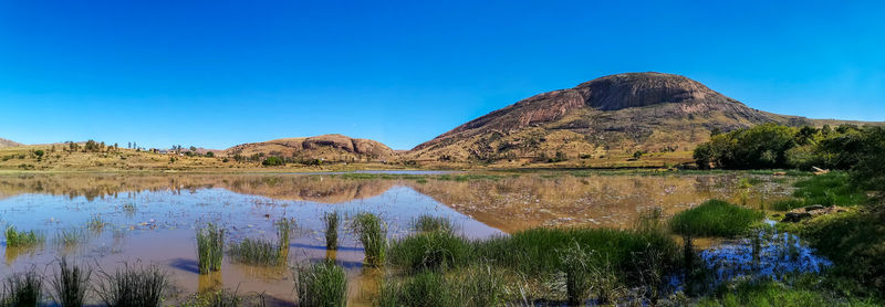 Scenic view of lake against clear blue sky