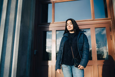 Full length of woman standing against window