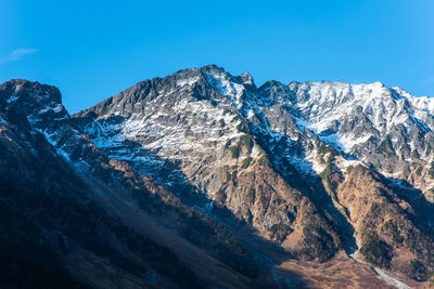 Scenic view of mountains against clear blue sky